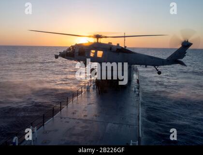 200211-N-JW440-1341 OCEANO PACIFICO (FEB 11, 2020) i guardsmen della Costa degli Stati Uniti del Maritime Safety Response Team (MSRT) West sono issati in un elicottero MH-60S Sea Hawk assegnato ai "Firehawks" dello Squadron 85 Di Combattimento del mare dell'elicottero mentre conducono le operazioni di addestramento dell'elicottero, del bordo, della ricerca e del sequestro al largo della costa di San Diego. MSRT West si è allenato con diversi squadroni provenienti da Helicopter Sea Combat Wing Pacific per imbarcarsi e proteggere le navi che possono essere tenute da terroristi che detengono ostaggi. (STATI UNITI Navy Photo by Mass Communication Specialist 2nd Class Rawad Madanat/Rilasciato) Foto Stock