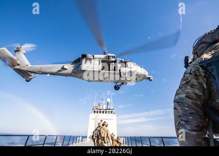 200213-N-JW440-1397 OCEANO PACIFICO (FEB 13, 2020) i guardsmen della Costa degli Stati Uniti del Maritime Safety Response Team (MSRT) West sono issati in un elicottero MH-60S Sea Hawk assegnato ai "Blackjack" dello Squadron Di Combattimento del Mare dell'elicottero 21 mentre conducono le operazioni di visita, bordo, ricerca e addestramento del sequestro dell'elicottero al largo della costa di San Diego. MSRT West si è allenato con diversi squadroni provenienti da Helicopter Sea Combat Wing Pacific per imbarcarsi e proteggere le navi che possono essere tenute da terroristi che detengono ostaggi. (STATI UNITI Navy Photo by Mass Communication Specialist 2nd Class Rawad Madanat/Rilasciato) Foto Stock