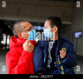 Pechino, Cina. 28th Feb, 2020. Il membro del team medico Zhang Zhijian (L) tiene il figlio prima di partire per la provincia di Hubei presso la stazione ferroviaria di Chongqing North nella Cina sud-occidentale di Chongqing il 28 febbraio 2020. Credito: Huang Wei/Xinhua/Alamy Live News Foto Stock