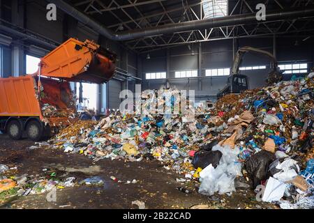 GRODNO, Bielorussia - Ottobre 2018: impianto di riciclaggio del processo di scarico di rifiuti dai camion della spazzatura. Carichi di manipolatore garbage sul trasportatore per ulteriori pro Foto Stock