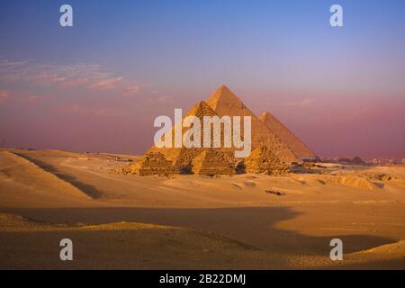 egitto cairo giza vista panoramica delle piramidi al tramonto, alba con cammello beduino caravane Foto Stock