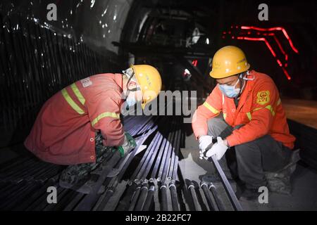 Chongqing. 29th Feb, 2020. I lavoratori lavorano in un cantiere di costruzione del Tunnel di Zengjiayan nel Distretto di Yuzhong, nel comune di Chongqing della Cina sud-occidentale il 29 febbraio 2020. La costruzione di grandi progetti locali è stata ripresa con misure rigorose adottate per prevenire e controllare la nuova epidemia di coronavirus. Credito: Wang Quanchao/Xinhua/Alamy Live News Foto Stock