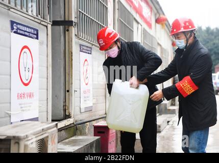 Chongqing. 29th Feb, 2020. I lavoratori della comunità prendono disinfettante per la costruzione del Tunnel di Zengjiayan nel distretto di Yuzhong, nel comune di Chongqing nella Cina sud-occidentale il 29 febbraio 2020. La costruzione di grandi progetti locali è stata ripresa con misure rigorose adottate per prevenire e controllare la nuova epidemia di coronavirus. Credito: Wang Quanchao/Xinhua/Alamy Live News Foto Stock