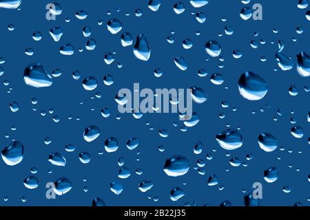 Gocce di pioggia su un colore del finestrino regolato per adattarsi al Pantone 19-4052 Classic Blue, colore dell'anno 2020. Colore PANTONE dell'anno 2020. Foto Stock