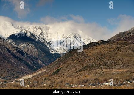 Grandi montagne innevate sopra l'alto villaggio di montagna in una bella giornata, Pirenei catalani, Spagna Foto Stock