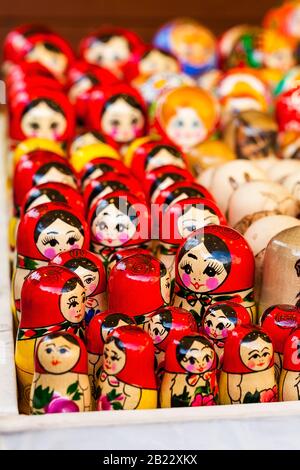 Un sacco di bambole tradizionali nazionali russe rosso matryoshka giocattolo, primo piano di mercato, fuoco selettivo. Concetto astratto dei simboli della cultura orientale slava Foto Stock