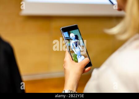 Donna che fotografa Pepper - assistente Android umanoide fatto in Giappone sul suo smartphone ai artificiale Foto Stock