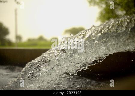 Corrente tubewell acqua dolce in campi durante l'estate Foto Stock