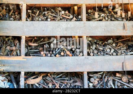 Primo piano di un armadio in legno con vecchi dadi e bulloni arrugginiti e oleosi utilizzati in un business auto junk shop a Iloilo City, Filippine, Asia Foto Stock