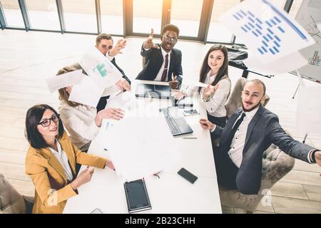 Gruppo multietnico di uomini d'affari che hanno un incontro d'affari. Team aziendale di successo in ufficio. Vista dall'alto Foto Stock
