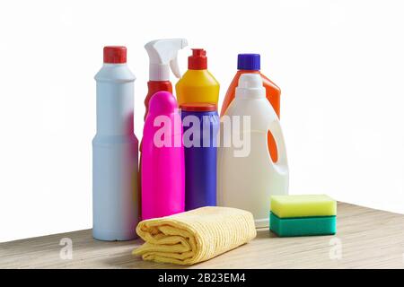 Bottiglie colorate di prodotti per la pulizia, spugna e straccio per la pulizia della casa su sfondo bianco Foto Stock