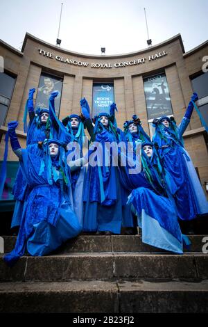 I Ribelli blu conducono centinaia di persone nella parata Blue Wave, organizzata da Extinction Rebellion, attraverso il centro di Glasgow per sensibilizzare i pericoli che Glasgow e il mondo si trovano ad affrontare a causa delle inondazioni causate dall'aumento dei livelli del mare e da un aumento delle tempeste. Foto Stock