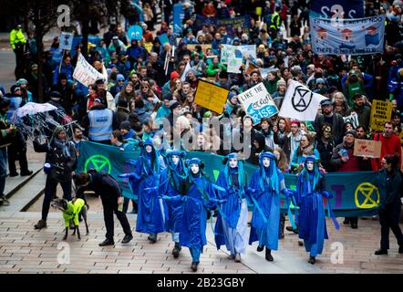 I Ribelli blu conducono centinaia di persone nella parata Blue Wave, organizzata da Extinction Rebellion, attraverso il centro di Glasgow per sensibilizzare i pericoli che Glasgow e il mondo si trovano ad affrontare a causa delle inondazioni causate dall'aumento dei livelli del mare e da un aumento delle tempeste. Foto Stock