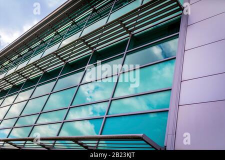 Moderna struttura architettonica edificio didattico con rivestimento esterno e travi in metallo con finestre riflettenti contemporanee A. Foto Stock