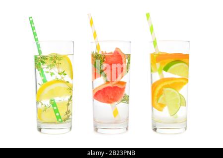Varietà di bevande all'acqua detox infuse di agrumi in bicchieri con cannucce di carta isolate su sfondo bianco Foto Stock