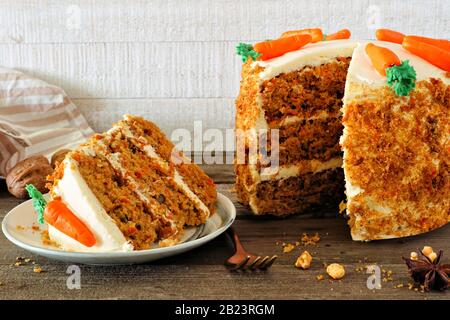 Fetta di torta di carote fatte in casa con formaggio cremoso glassante e carote fondenti. Vista laterale scena tavolo con uno sfondo di legno bianco. Foto Stock