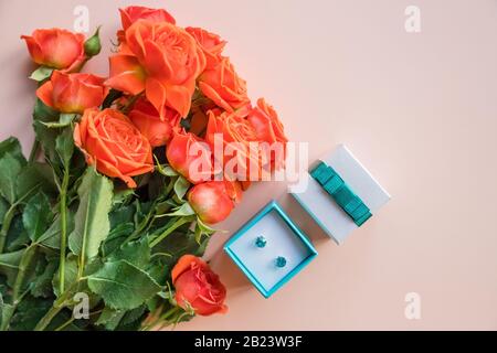 Regalo di San Valentino su sfondo pastello. Scatola bianca con gioielli e rose arancioni. Bel regalo per il giorno delle donne, concetto di San Valentino. San Valentino Foto Stock