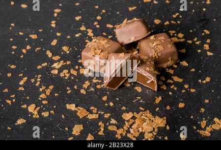 Cioccolatini belgi al caramello fatti in casa su sfondo scuro Foto Stock