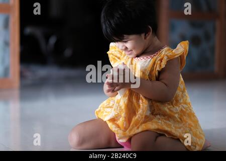 primo piano di bambina giocosa sul pavimento Foto Stock