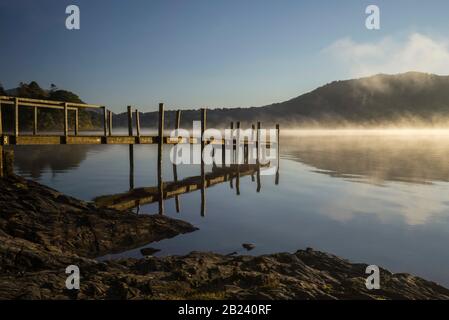 Riflessioni di colline lontane all'alba, Derwentwater, Lake District National Park, Cumbria, Inghilterra, Regno Unito Foto Stock