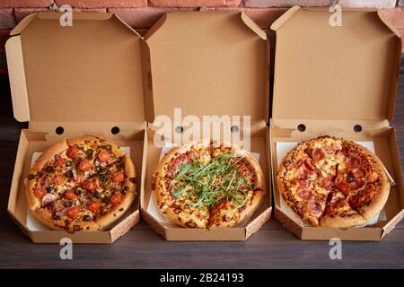 Tre diversi tipi di pizze in scatole di consegna Foto Stock