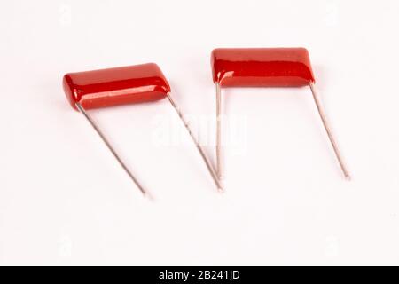 I condensatori rossi da primo piano si trovano su un tavolo bianco durante la produzione di apparecchiature per ufficio e potenti computer per l'estrazione mineraria e i videogiochi. Luogo per l'annuncio Foto Stock