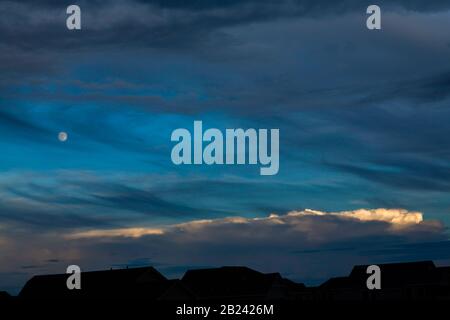 Paesaggio notturno, con cielo blu a strati, luna, banda di nube luminosa e silhouette Foto Stock