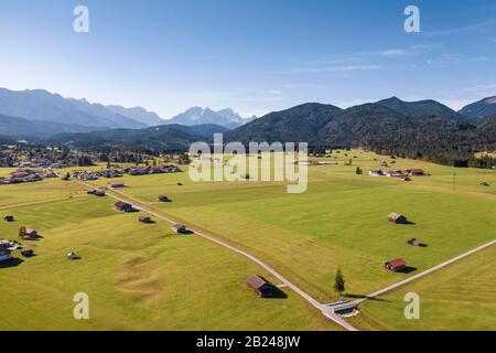 Veduta aerea, campi con fienili, colline bavaresi delle Alpi, terra di Werdenfelser, Wetterstein Range, alta Baviera, Baviera, Germania Foto Stock