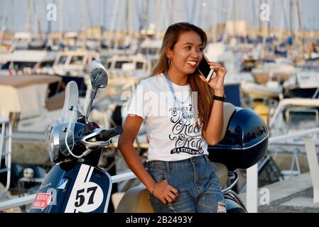 Donna con Vespa 125 Primavera nel porto di Penelope, Porto Senigallia, Senigallia, provincia di Ancona, Marche, Italia Foto Stock