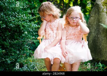 Ritratto di due sorelle seduti insieme su una sedia da giardino (6 anni, 3 anni), Repubblica Ceca Foto Stock