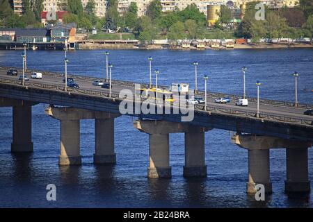 Kiev, Ucraina - 26 aprile 2018: Ponte di Paton attraverso il Dnieper a Kiev tra Pechersk e Bereznyaki. Paesaggio urbano con trasporto sul ponte Foto Stock