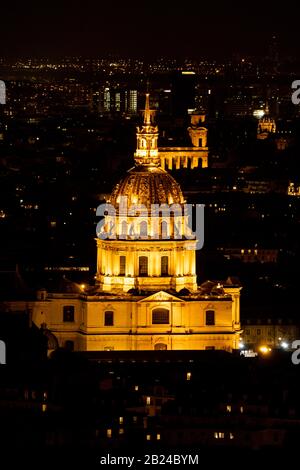 Les Invalides (Hôtel National des Invalides) illuminato di notte, come visto dalla Torre Eiffel, Parigi, Francia. Foto Stock