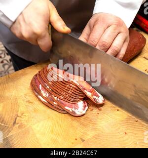 Un Vendor affina pancetta al suo cliente. Bazaar Egiziano, Istanbul, Turchia. Foto Stock