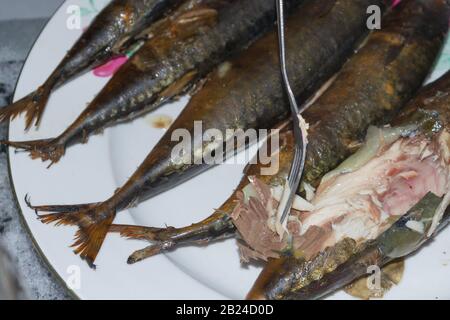 Lo sgombro di pesce fresco affumicato è caldo su un piatto di ceramica Foto Stock