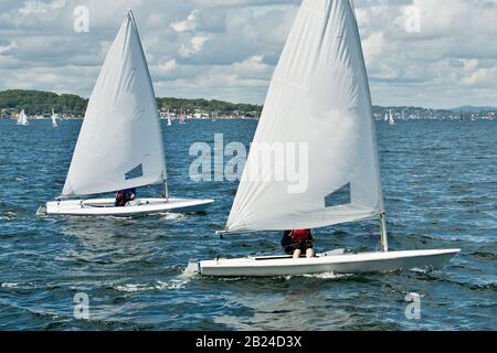 Bambini che navigano in piccole barche colorate e gommoni per divertirsi e in competizione. Lavoro di squadra da parte dei marinai junior che corrono sul lago di acqua salata Macquarie. Phot Foto Stock