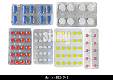 Pillole di diversi colori in blister, isolato su sfondo bianco Foto Stock