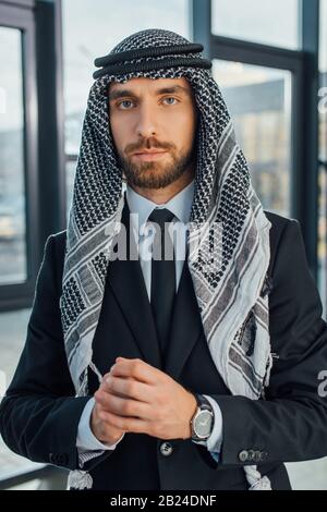 bell'uomo d'affari arabo in piedi in ufficio moderno Foto Stock