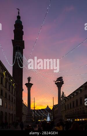 Colonne in Piazza dei Signori e la Basilica Palladiana nel periodo natalizio con le luci a cascata di Torre Bissara al tramonto. Vicenza Foto Stock