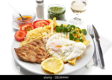 Piatto per pranzo a base di carne fritta, costolette di maiale con uova, patate. Piatto portoghese Foto Stock