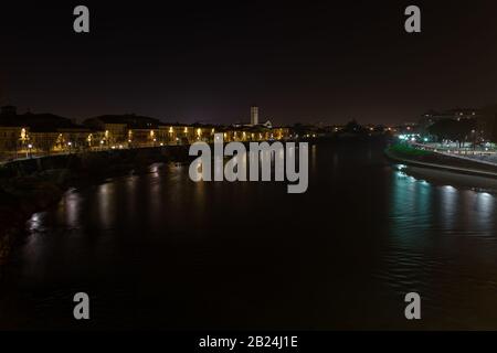 Vista di Verona e del fiume Adige dal ponte di Castelvecchio, conosciuto anche come il ponte Scaliger di notte, Italia Foto Stock