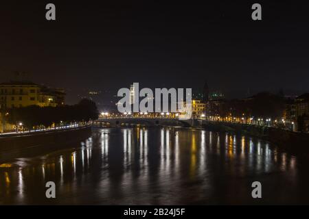 Vista di Verona e del fiume Adige dal ponte di Castelvecchio, conosciuto anche come il ponte Scaliger di notte, Italia Foto Stock