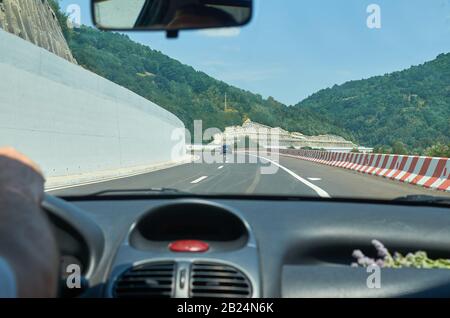 Nuova autostrada appena aperta per il traffico attraverso una pittoresca gola, vista da un veicolo in movimento Foto Stock