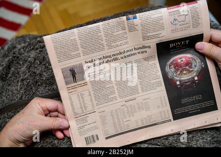 Parigi, Francia - 19 febbraio 2020: POV of Senior Hands holding Latest Financial Times Newspaper che presenta l'articolo sulla ricerca dell'anima nell'aldilà digitale e nella pubblicità di Bovet Foto Stock