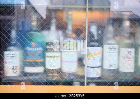 Bottiglie di whisky scozzese in una finestra di un bar giapponese. Foto Stock