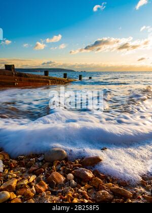 Lunga esposizione di groynes al tramonto a Milford-on-Sea Foto Stock