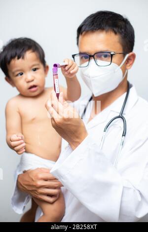 Il medico tiene il vaccino del vaccino di Covid-19 intube trasporta il bambino ragazzo sul concetto sano di fondo bianco Foto Stock