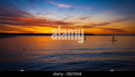 Colori profondi di arancio e rosso nei cieli sopra un molo Poole Harbor vicino a Sandbanks Foto Stock