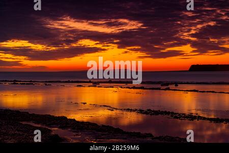 Il cielo si schiarisce dopo una tempesta di pioggia appena abbastanza a lungo per mostrare le profonde nuvole rosse e viola sulla costa sud del dorset jurassic Foto Stock