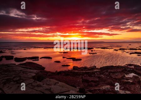 Il cielo si schiarisce dopo una tempesta di pioggia appena abbastanza a lungo per mostrare le profonde nuvole rosse e viola sulla costa sud del dorset jurassic Foto Stock