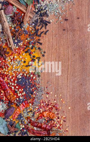 Spezie aromatiche su una tavola di legno a lato della cornice Foto Stock